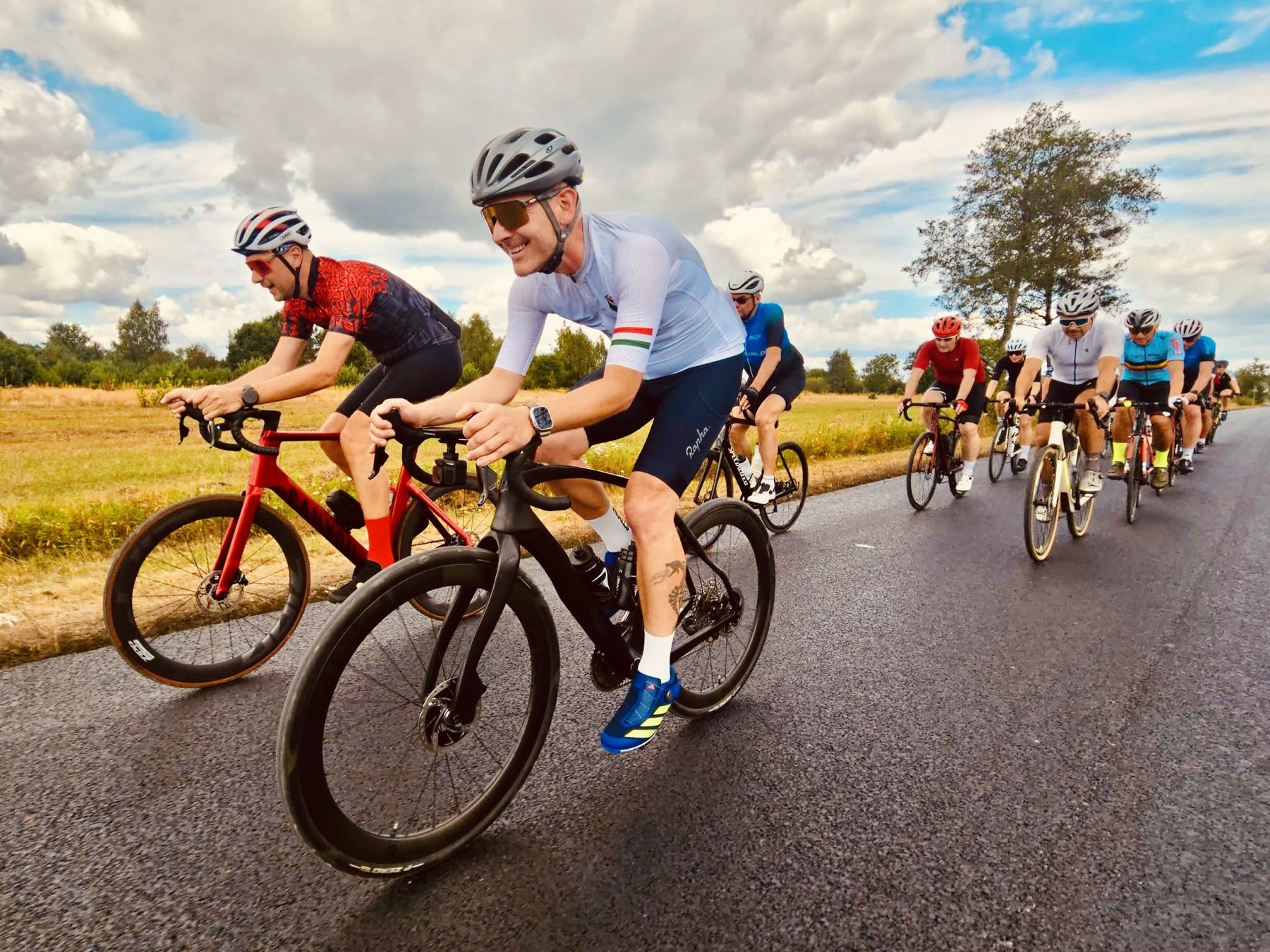 Group road ride under dramatic clouds